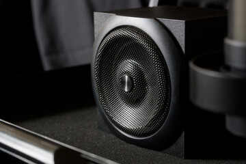 
A sleek, modern black audio speaker, part of a professional sound setup, features a detailed...