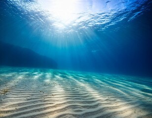 underwater shaft of light illuminating sandy ocean floor