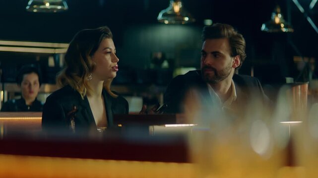 Beautiful Caucasian couple having a date in a stylish restaurant, talking and laughing. Shot with 2x anamorphic lens