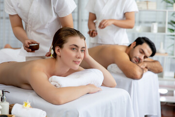 Woman customer having exfoliation treatment in luxury spa salon with warmth candle light ambient....