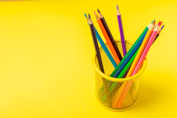 Colored pencils on a bright colored background. Equipment for coloring. Stationery for...