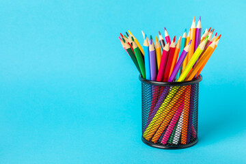 Colored pencils on a bright colored background. Equipment for coloring. Stationery for...