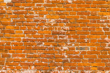 Close-up of a weathered red brick wall in Newtown, Isle of Wight, showing details of texture and...