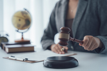 Justice's Gavel: A legal professional's hand poised over a ceremonial gavel, near a desk globe and...