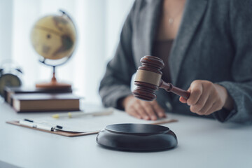 Justice in Hand: A close-up shot features a person's hand poised to strike the gavel, symbolizing...