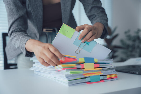 Organizing the Documents: A dedicated office worker is meticulously organizing the documentation, ensuring efficiency in workflow. Meticulous organization brings precision and attention to detail.