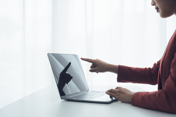 Focus and Innovation: A businesswoman attentively using a laptop computer in a bright and modern office setting, where she explores new technology
