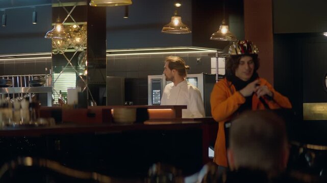 TRACKING CU Portrait of food delivery courier in bicycle helmet leaving a restaurant after picking up order for delivery. Shot with 2x anamorphic lens