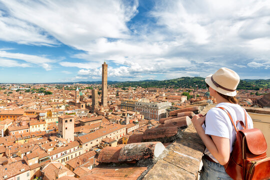 Beautiful happy traveler girl looking and enjoying visiting the historic city of Bologna, Italy. - Powered by Adobe