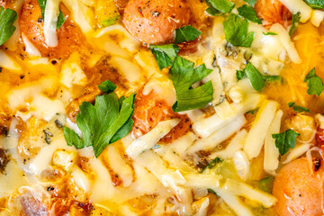 Background with the texture of an omelet with vegetables, sausages, cheese and parsley. Close-up, top view