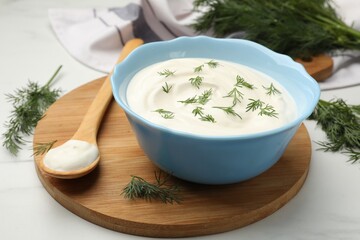 Tasty sour cream with dill on white table, closeup