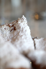 A close up of beignets covered in powered sugar 