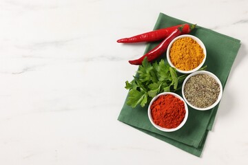 Different aromatic spices on white marble table, top view. Space for text
