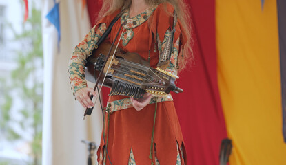 Woman playing nyckelharpa at folk music festival.
