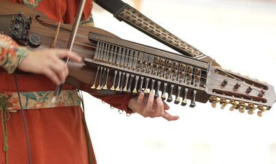 Woman playing nyckelharpa at folk music festival.