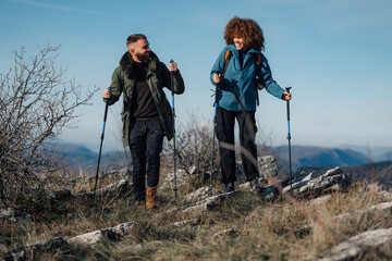 Hikers walking on mountain top using trekking poles