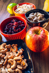 Still life of nuts, fresh fruit, and cereals on wood with studio lighting. Concept of veganism, nuts, healthy food, healthy desserts, and diets.