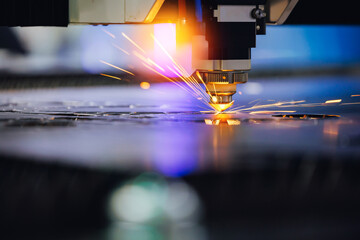 Blue color Laser CNC cut of metal with light spark, technology modern industrial