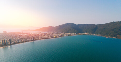 Aerial view of Da nang's coastal landscape with mountains and urban skyline at sunset