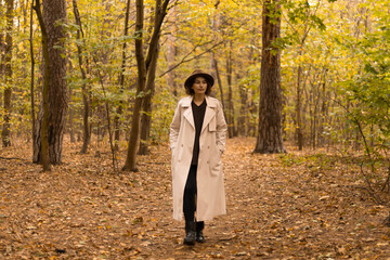 Rear view of a woman enjoying a peaceful walk among trees in fall attire