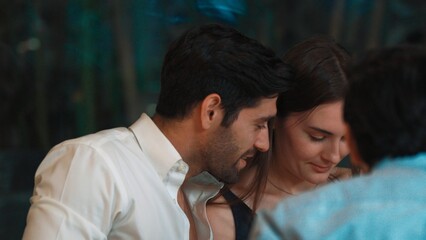 Portrait closeup smart man talking engaging in lively conversation with group friend or couple at dinner table in enjoy meeting special party at luxurious pub and restaurant at night time. Vinosity.