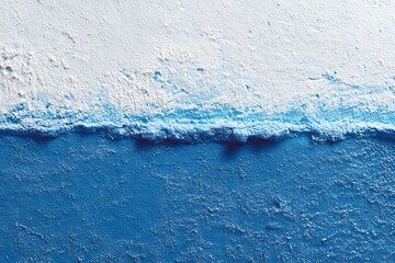 A textured wall with a striking contrast between vibrant blue and clean white, creating an abstract and modern design.