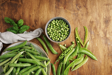 Green pea in bowl of top view on rustic wooden background with copy space, natural wooden table. Flat lay.