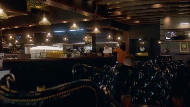 Food delivery courier in bicycle helmet entering the restaurant to pick up order for delivery. Shot with 2x anamorphic lens