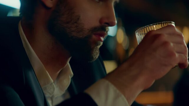 Beautiful Caucasian male sitting in a stylish restaurant, drinking cocktail. Shot with 2x anamorphic lens