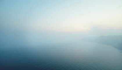 Fototapeta premium Misty Coastal Scene at Dawn with Calm Waters and Soft Colors