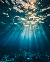 Obraz premium Sunbeams penetrating clear ocean water creating a mesmerizing underwater scene