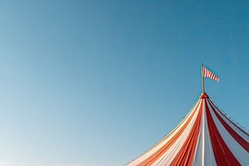 Brightly striped tent reaches towards clear blue sky, evoking fe