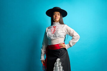 Studio portrait of a young latina woman proudly wearing a traditional chilean huasa dress, complete...