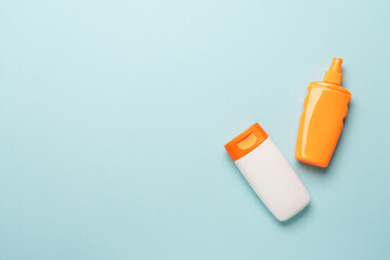 Sunscreen, sun cream and sunglasses on blue background.