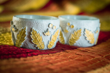 Two beautiful candlesticks decorated with strawberry leaves stand on a striped tablecloth. High quality photo