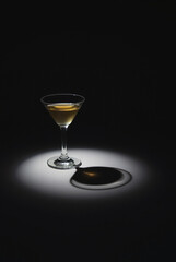 Cocktail Glass Shadow — Dramatic Low-Angle Light Casting Sharp Shadow on Dark Surface