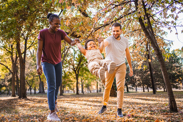 Joyful swing between parents in the park