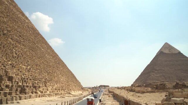 Two massive pyramids at Giza with tourist pathway between them. Ancient Egyptian monuments of pharaonic burial architecture in desert