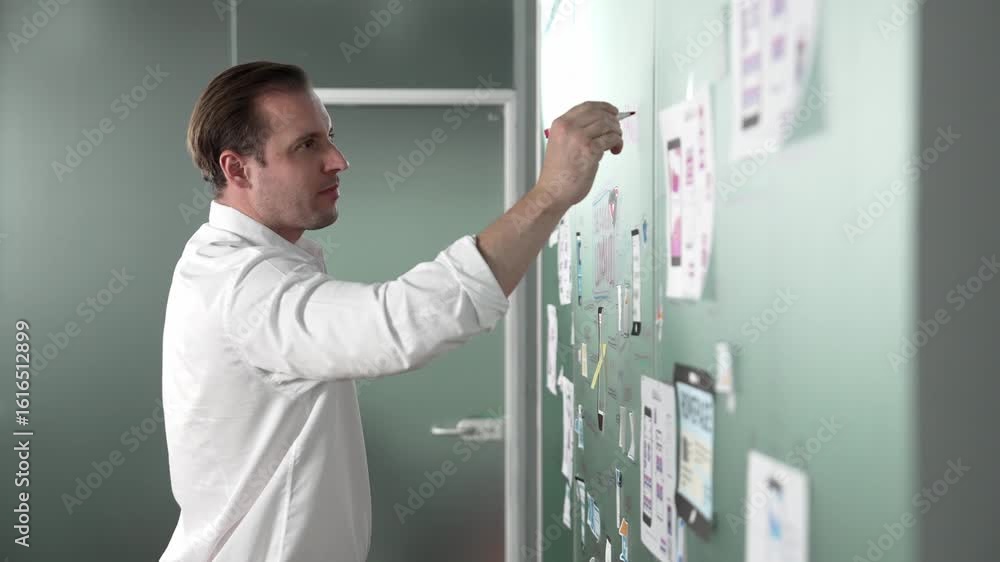 Poster professional start up project manager writing on board with ux and ui design. young handsome busines