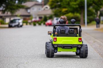 Toddler Driving a Green Toy Car on a Quiet Street in Vancouver
