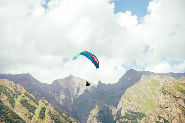 Paragliding against the backdrop of a clear blue sky and mountains.Papraplans in Chegem,...