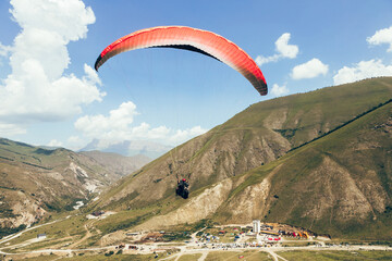 Paragliding against the backdrop of a clear blue sky and mountains.Papraplans in Chegem,...