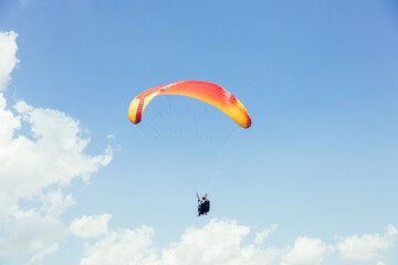 Paragliding against the backdrop of a clear blue sky and mountains.Papraplans in Chegem, Kabardino-Balkaria