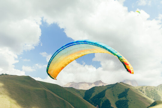 Paraglider wing against the blue sky and picturesque mountains. gliding in chegem