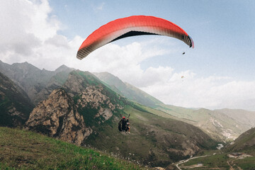 Paragliding against the backdrop of a clear blue sky and mountains.Papraplans in Chegem,...