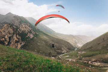 Paragliding against the backdrop of a clear blue sky and mountains.Papraplans in Chegem,...