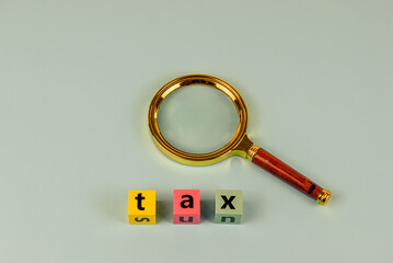 Tax time scrutinized. A magnifying glass focuses on the word "tax.