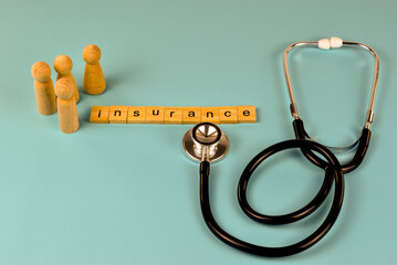 Wooden figurines and a stethoscope, positioned apart, symbolize the importance of health insurance.