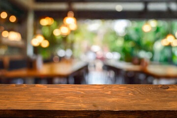 Empty wooden table  bokeh light background. Tables and chairs in the lobby of restaurant. Visitors to restaurant for dinner. Cozy bokeh lightening. Beautiful bright interior. Blurred bokeh basic