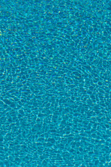 Reflets d'eau cristalline dans une piscine, capturés durant une belle journée ensoleillée.